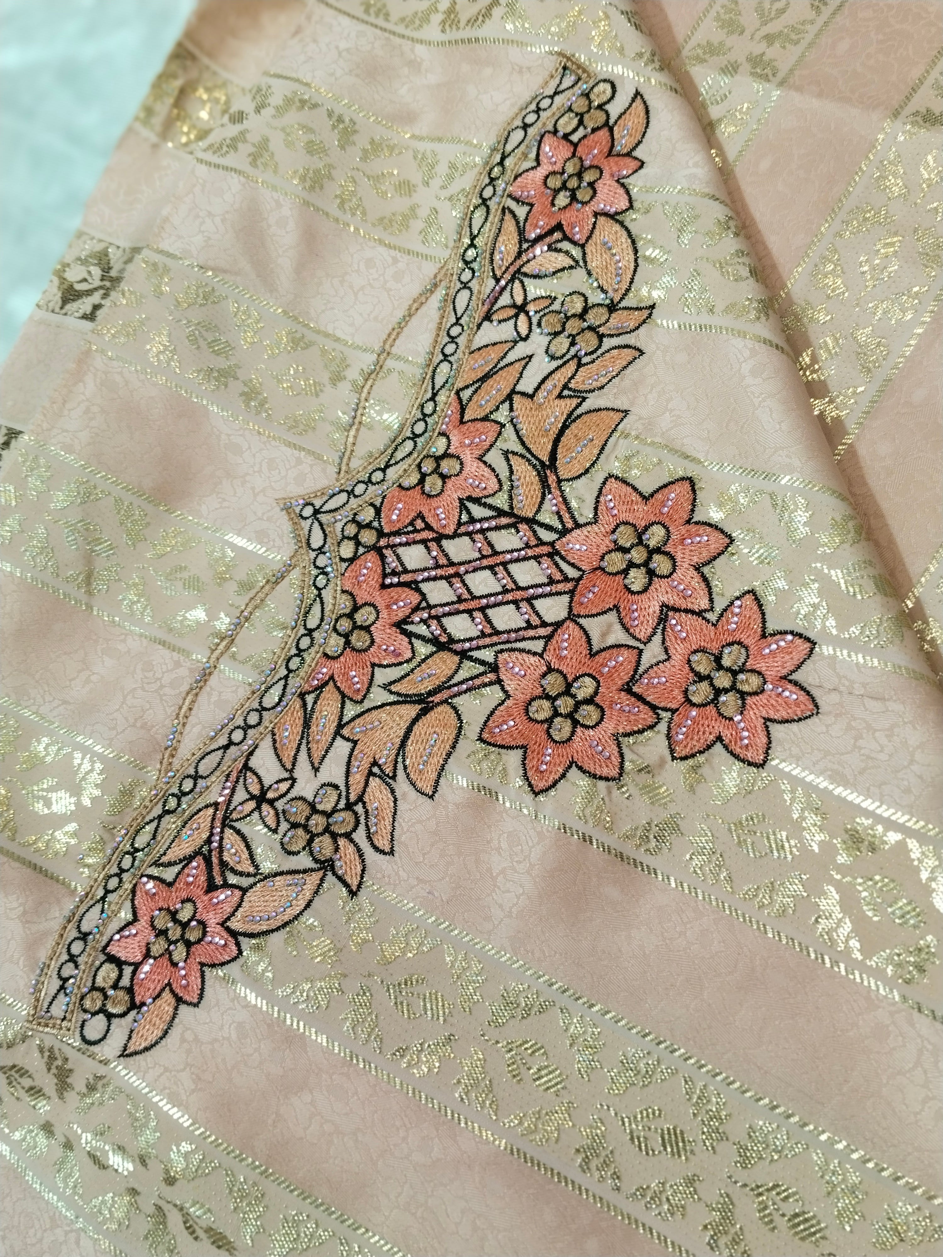 Close-up of embroidered fabric with floral design on a light pink background
