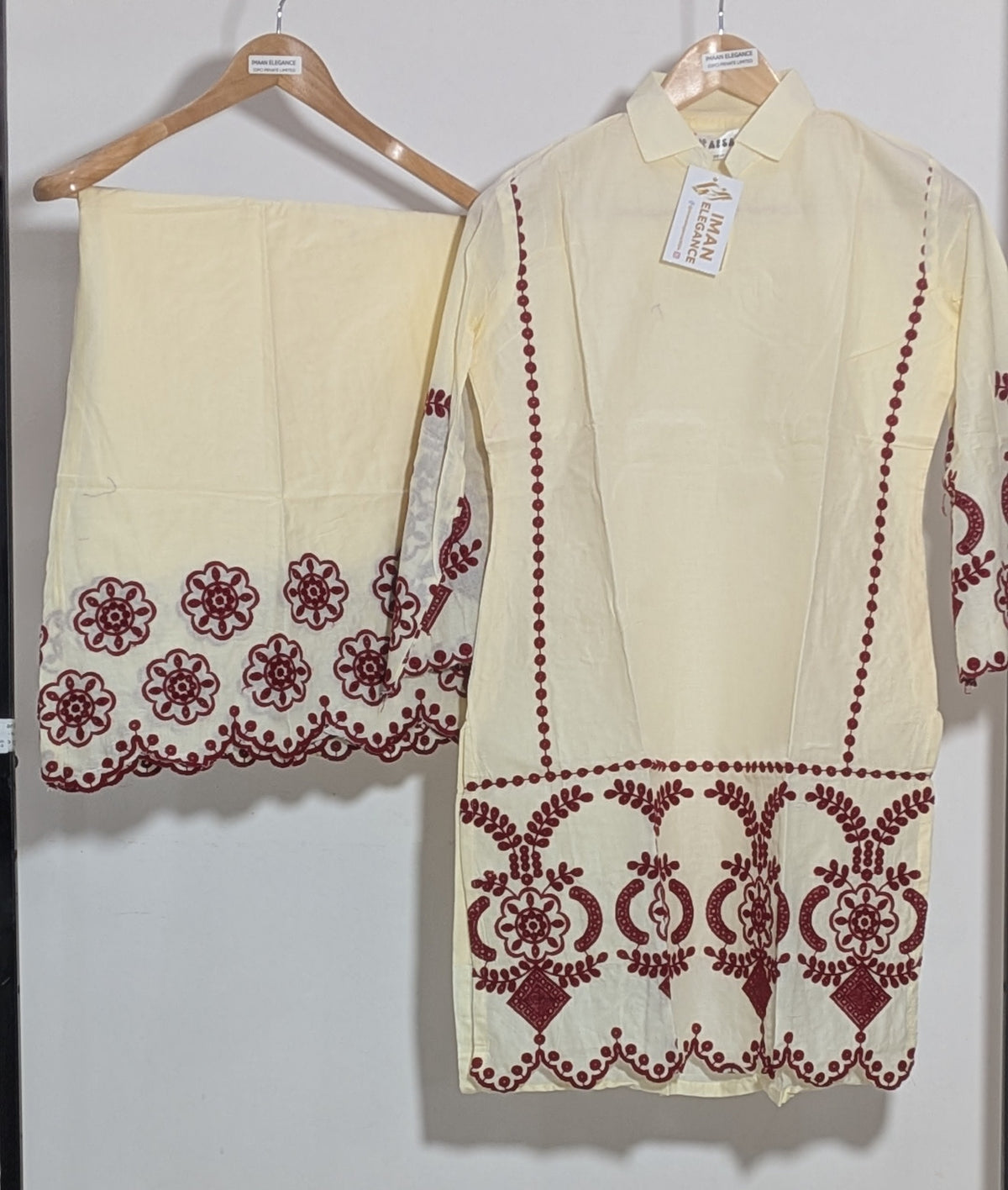 White outfit with red embroidery on a hanger against a white background