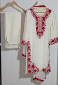 White outfit with red embroidery on a hanger against a white background