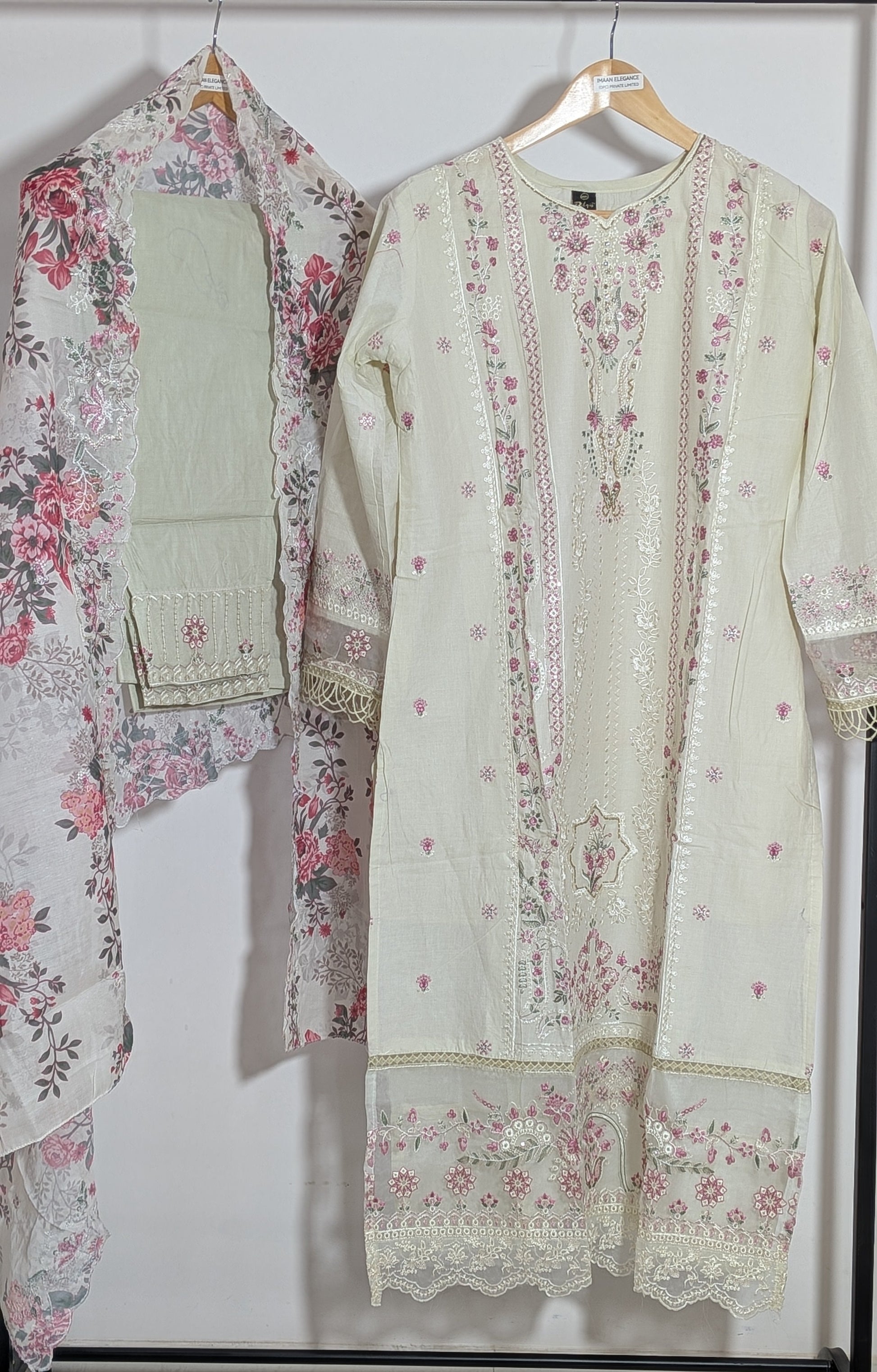 Light-colored embroidered outfit with floral patterns on a white background